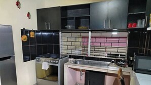 A compact kitchen with a gas stove, a sink, and a small refrigerator.