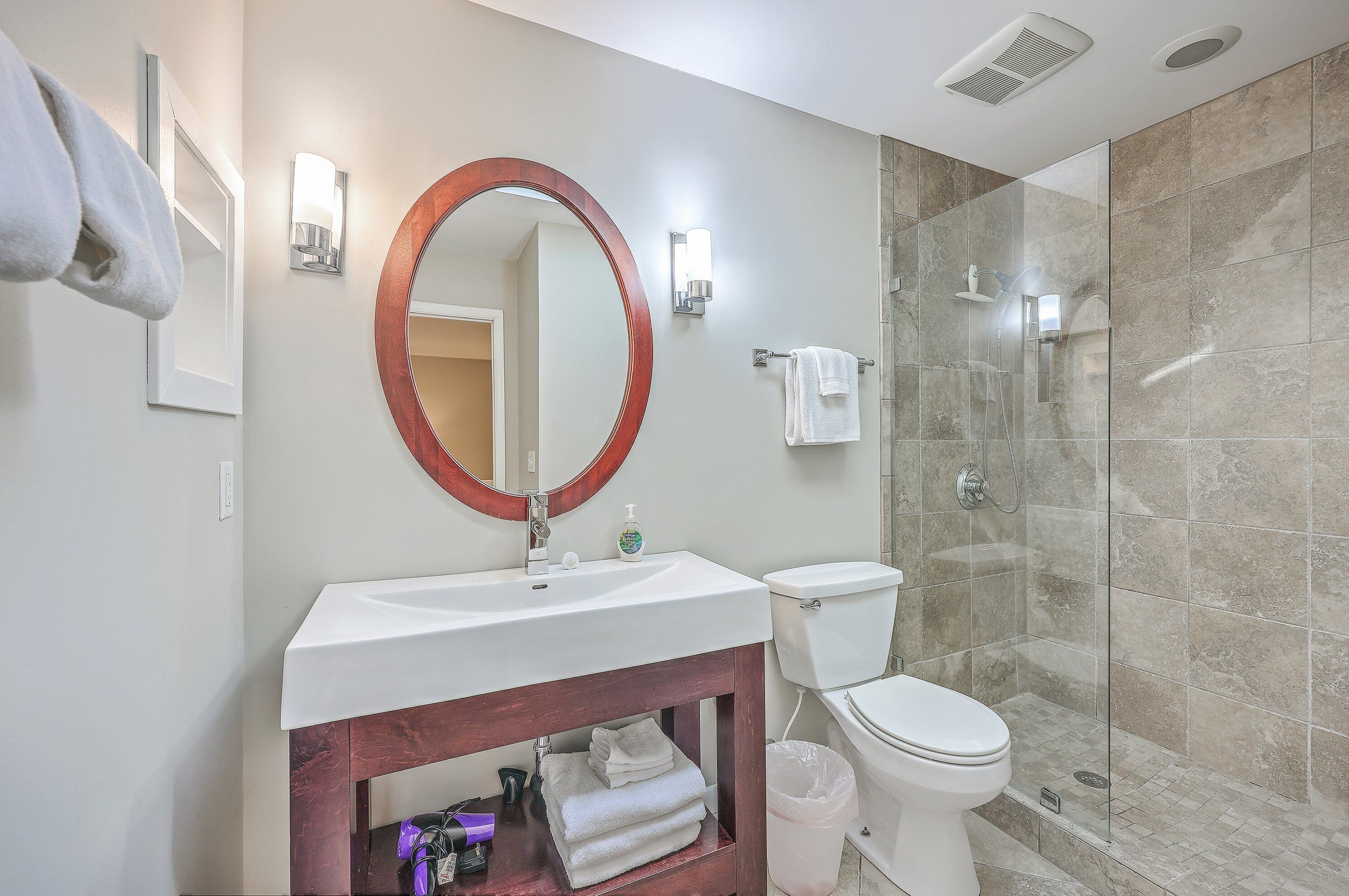 A bathroom with a sink, toilet, and glass-enclosed shower.
