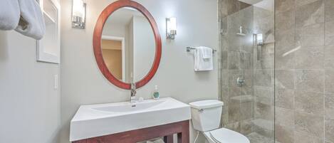A bathroom with a sink, toilet, and glass-enclosed shower.