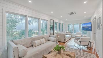 A spacious living room with a large sofa, a coffee table, and a TV.