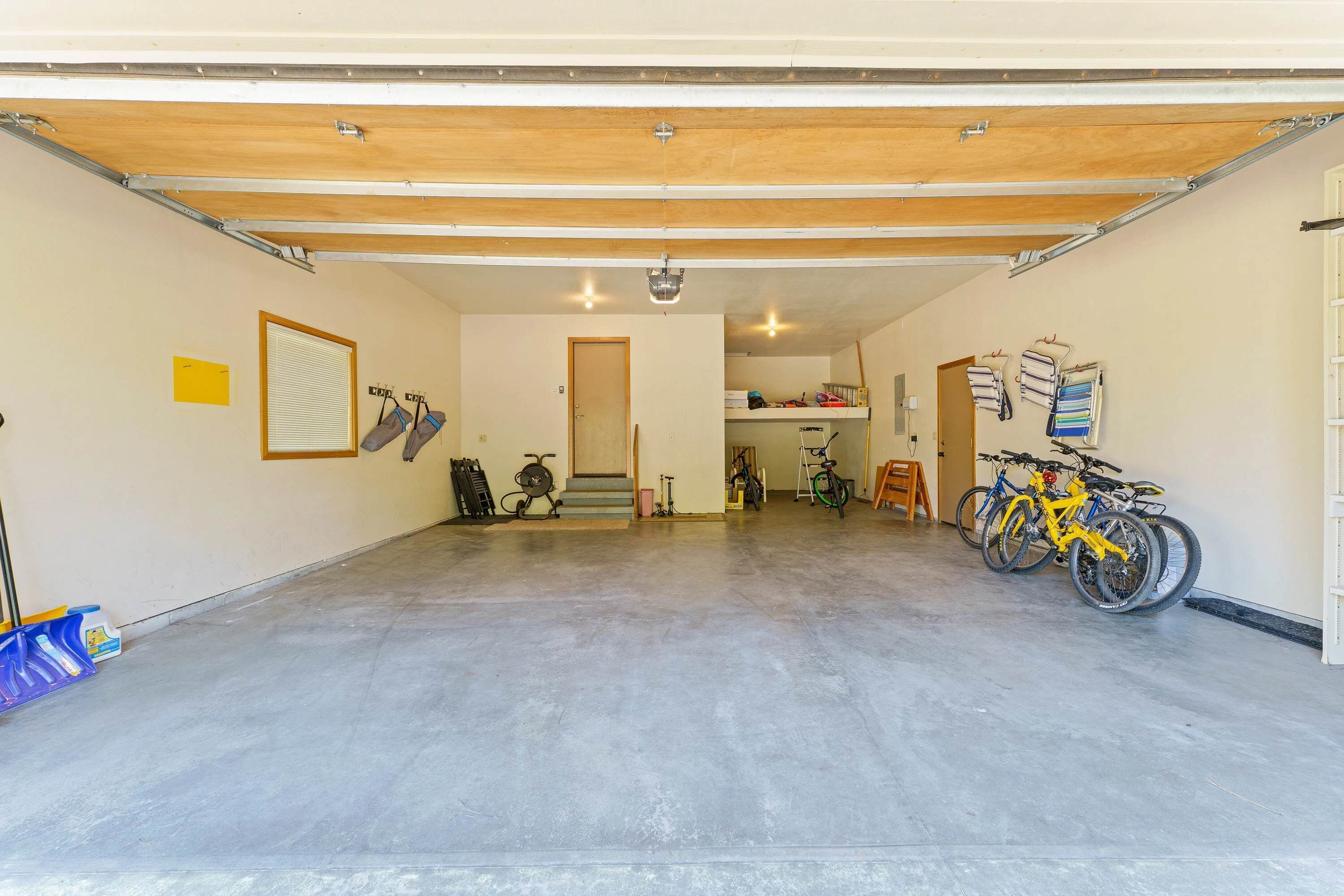 Garagem com piso de concreto, bicicletas e suporte para bicicletas.