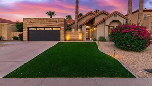 A modern house with a well-maintained lawn, a garage, and a driveway. - 110th Scottsdale (Scottsdale)