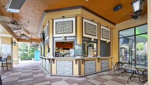 Una zona de bar con suelo de baldosas, una barra con la carta y vistas al exterior.