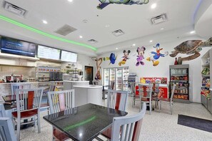 Un restaurante con mostrador, asientos y una pizarra de menú.