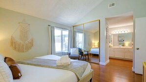Une chambre d’hôtel équipée d’un lit, d’une chaise, d’un miroir et d’une kitchenette.