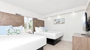 A modern bedroom with two beds, a TV, and a wooden cabinet. - Walk to Beach & Boardwalk • Pool • Family Suite Sleeps 8 • Full Kitchen (Myrtle Beach)