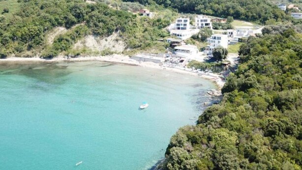An aerial view of a coastal area with buildings, a beach, and a boat. - Casa Mila Apartments - Standard Triple bedroom with sea view (Ulcinj)