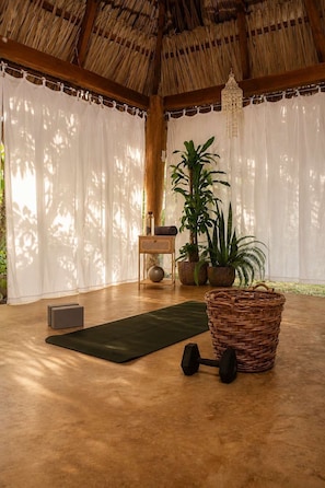 A room with a thatched roof, a yoga mat, a wicker basket, and exercise equipment. - Nukumi Club — Adults-Only Boutique Hotel in Santa Catalina, Panama (Santa Catalina)