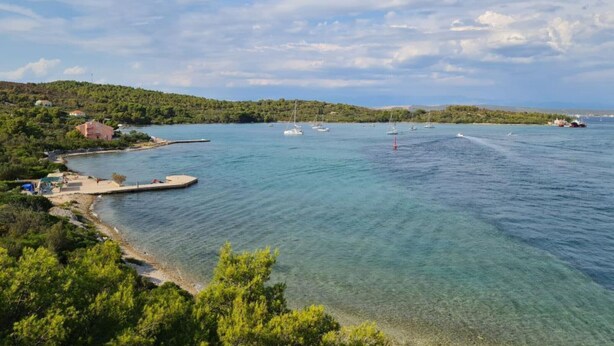 A coastal area with clear waters, boats, and a small pier. - Apartments Nena - Studio apartment (Ugljan)