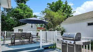 A deck with a grill, outdoor furniture, and a covered table area. - Saratoga Track House, Pet Friendly, Workspace (Saratoga Springs)