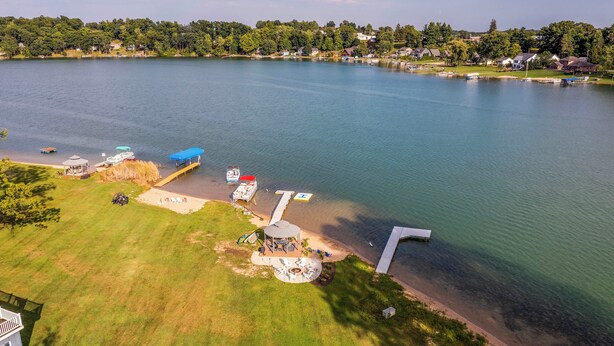 A lakeside property with a dock, a gazebo, and a grassy area. - Private Beach, 3,000 Sq Ft: Murray Lake Retreat! (Lowell)