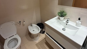 Un bagno con WC, bidet, lavabo e specchio.