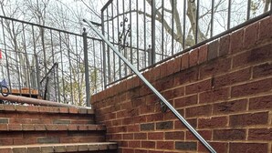 A set of brick stairs with metal railings, leading to a higher level. - Historic English Basement – Elegant Old Town, Alexandria Retreat (Alexandria)
