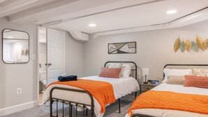 Ein Schlafzimmer mit zwei Betten, einem Nachttisch, einem Spiegel und einem Wandbild.