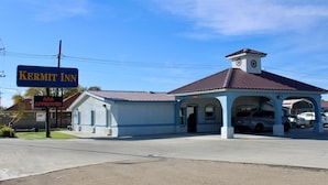 A Kermit Inn with a blue facade, a clock tower, and a covered parking area. - Kermit Inn (Kermit)