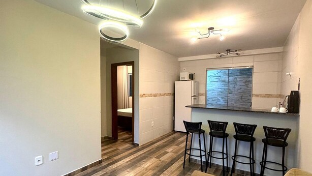 Eine moderne Küche mit Bar, einem Essbereich inklusive Sofa und einem gemusterten Boden.