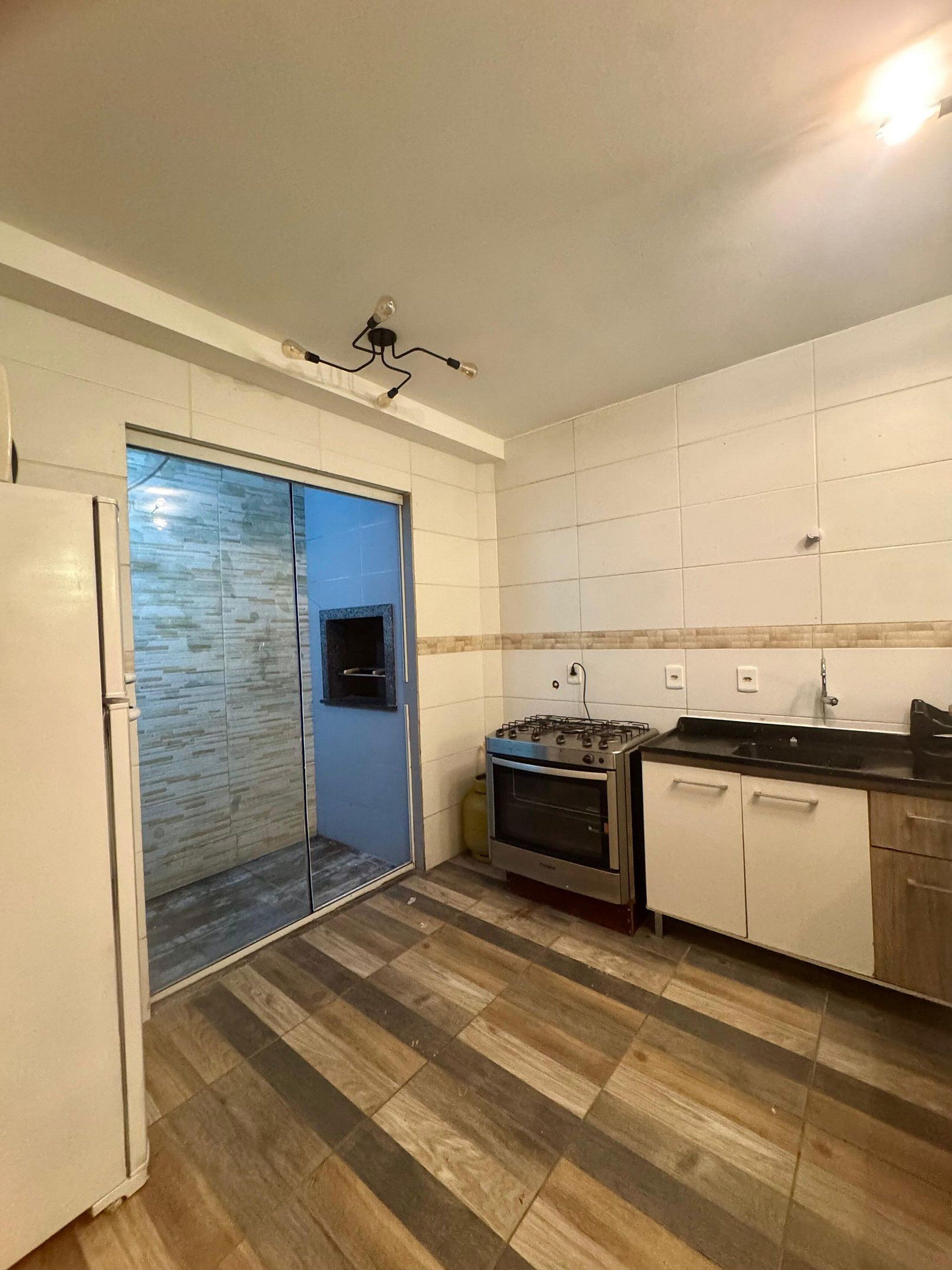 Una cocina con estufa a gas, horno y refrigerador.