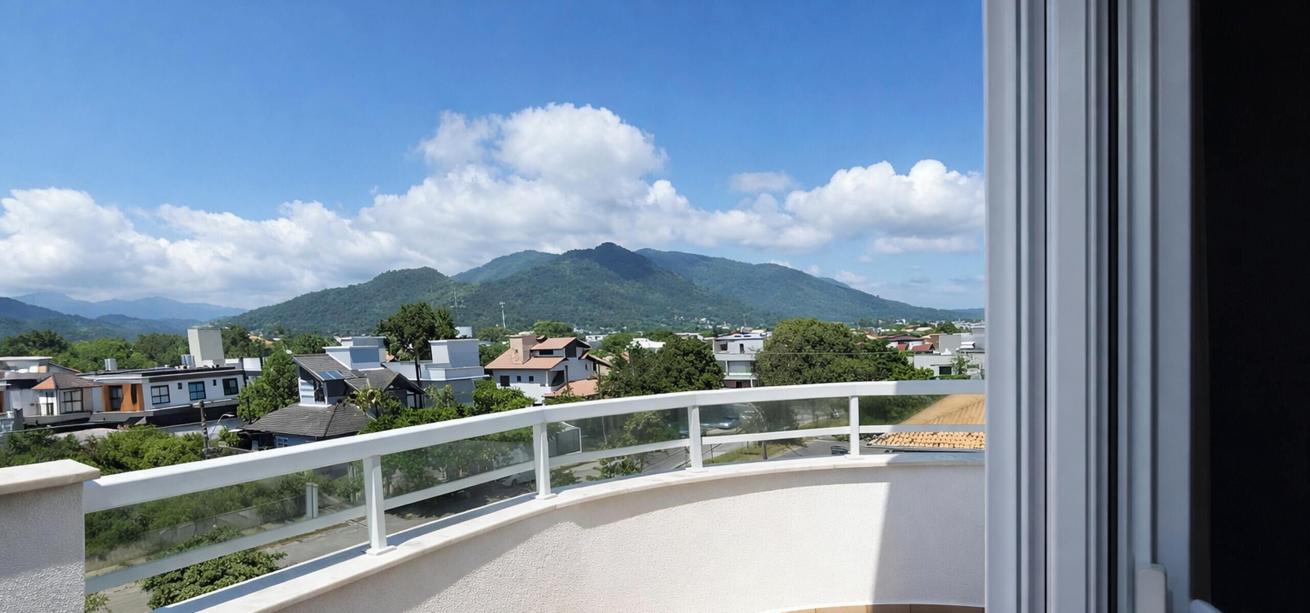 Un balcón con vistas a una zona residencial y una montaña.