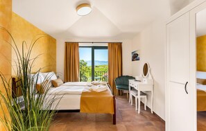 A bedroom with a bed, a desk, and a view of the outdoors. - Amazing home in Vrbnik with sauna (Vrbnik)