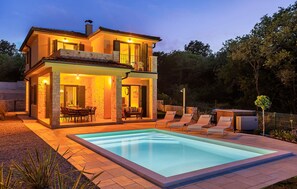 A two-story house with a swimming pool, outdoor seating, and a well-lit patio area. - Amazing home in Vrbnik with sauna (Vrbnik)