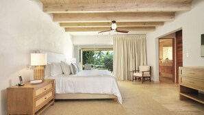 Ein Schlafzimmer mit Bett, Nachttisch, Lampe und Deckenventilator.