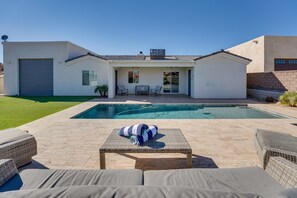 Una casa moderna con piscina, mobiliario exterior y garaje.