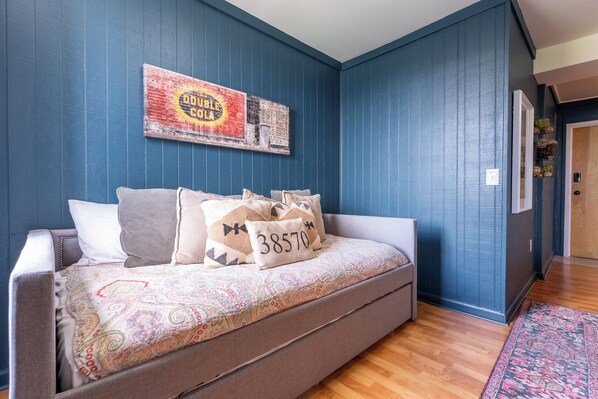 A bedroom with a bed, a wall clock, and a door.