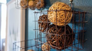 Wicker balls displayed on metal wire racks against a blue wall. - The Mason Apartment-Cozy Getaway (Livingston)