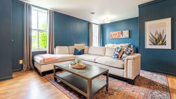 A living room with a sectional sofa, a coffee table, and a patterned rug. - The Mason Apartment-Cozy Getaway (Livingston)