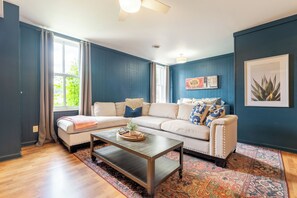 A living room with a sectional sofa, a coffee table, and a patterned rug.