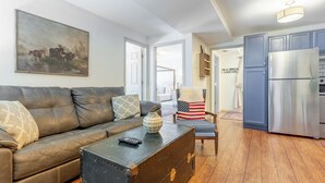 Un salon avec un canapé en cuir marron, une table basse et un tableau accroché au mur.