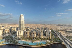 A high-rise building with a modern design, surrounded by residential buildings and a large body of water with a bridge. - A Free Housekeeping Visit FOR Every Stay Between THE 16th FEB AND THE 16th MAR - Stayshort - Luxury 3 Bedroom in Dubai Creek Harbour That Sleeps 6 (Dubai)
