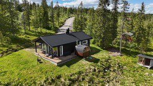 A cabin with a deck, a large barrel, and a small shed. - Family Cabin Budor - 60 MIN From OSL - Sauna & Hedmarksvidda (Loten)