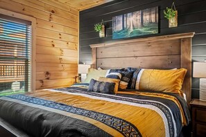 Ein Schlafzimmer mit einem großen Bett, einem Holzkopfende und einem Fenster mit Jalousien.
