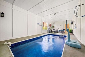 Ein Hallenbad mit Basketballkorb, einer Lounge und Blick ins Freie.