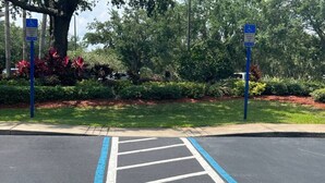 A parking lot with a handicapped parking space marked by blue lines and a white cross. - 2 Bedroom Deluxe - Theme Park (Orlando)