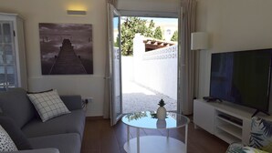 A living room with a sofa, a coffee table, a TV, and a painting. - 05 Ch3200 in Denia With 3 Bedrooms and 2 Bathrooms (Denia)