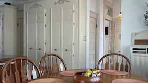 Ein Esszimmer mit Holztisch, sechs Stühlen und einer dekorativen Schale in der Mitte.