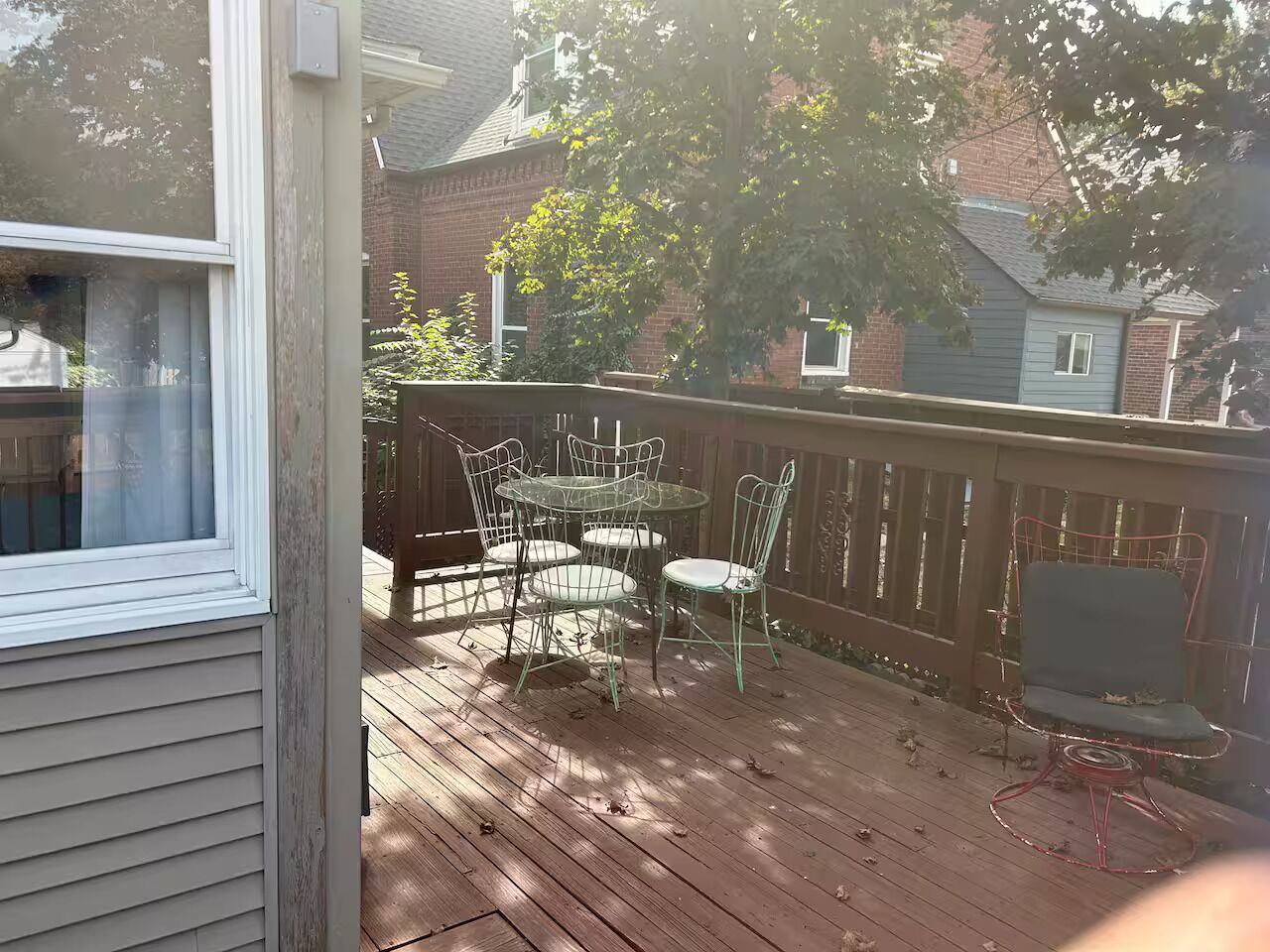 A wooden deck with a table and chairs, surrounded by a wooden fence.