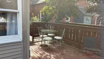 A wooden deck with a table and chairs, surrounded by a wooden fence.