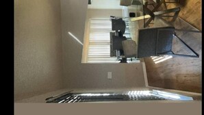 A room with a bed, a desk, and a chair. There is a window with blinds, and a wooden floor. - Orlando Getaway 3/2 Close to Theme Parks (Orlando)