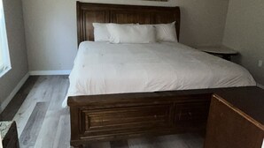 A bedroom with a wooden bed, a ceiling fan, and a painting on the wall. - Orlando Getaway 3/2 Close to Theme Parks (Orlando)
