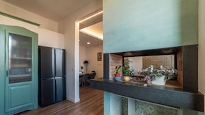 Een keuken met een zwarte koelkast, een blauwgroene kast en een aanrecht met planten.