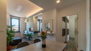 Een moderne woonruimte met een eethoek, een keuken en uitzicht over de stad.
