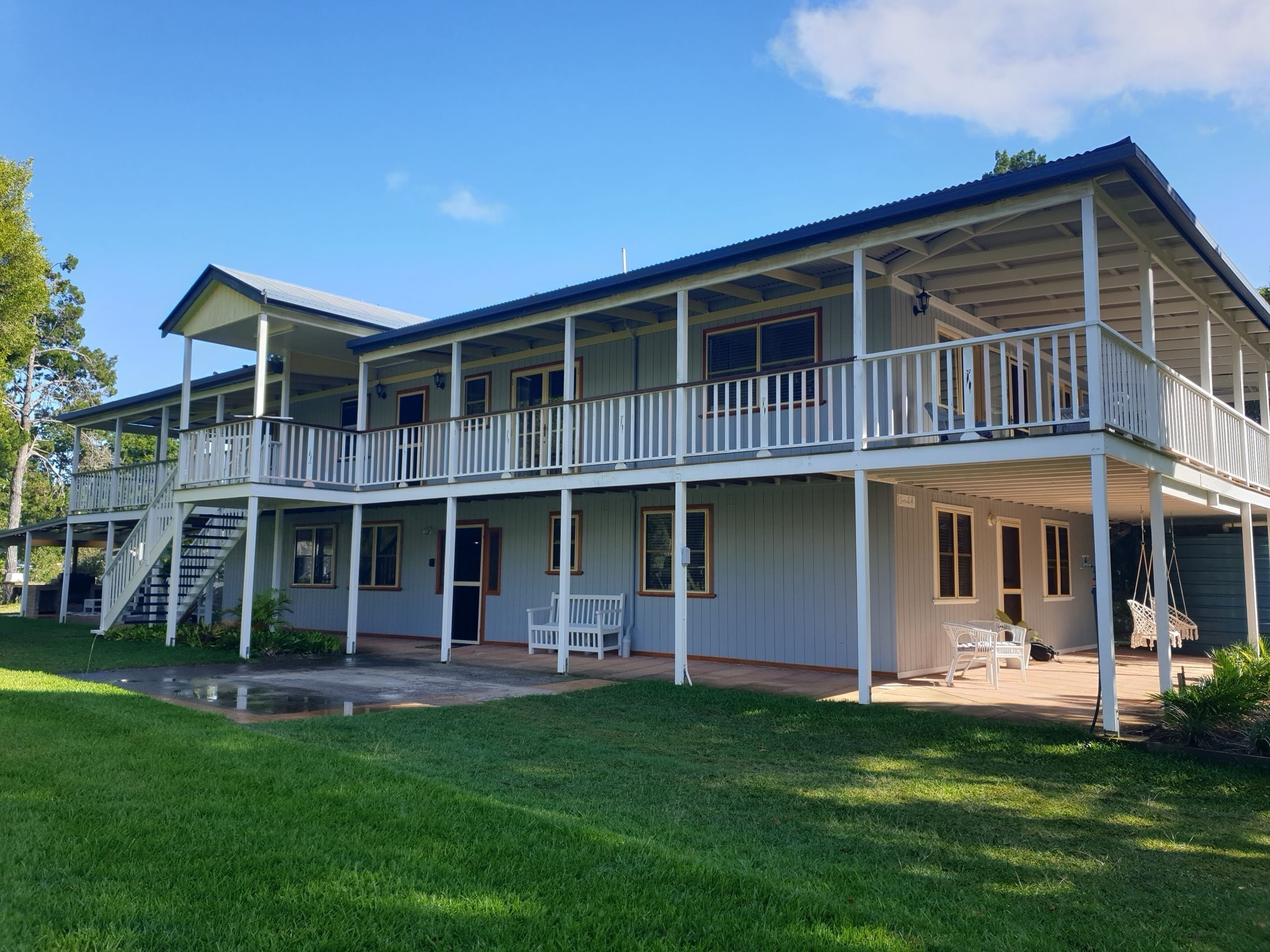 A two-story house with a balcony, a staircase, and a porch area.