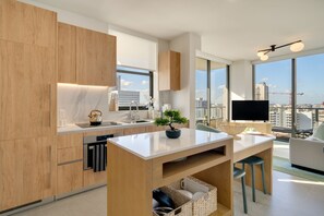 Eine moderne Küche mit Holzschränken, einer Marmorarbeitsplatte und Blick auf die Stadt.