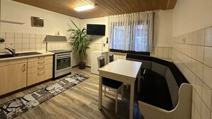 A compact kitchen with a stove, sink, and dining area. - Holiday Oasis 2.0 near Legoland Günzburg (Günzburg)