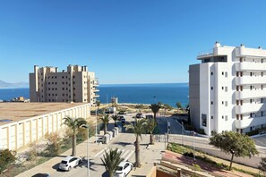 Un área urbana costera con edificios modernos, un cielo azul despejado y vista al mar.