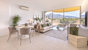 Una sala moderna con comedor, ventanas amplias con vistas a la montaña y un televisor de pantalla plana.