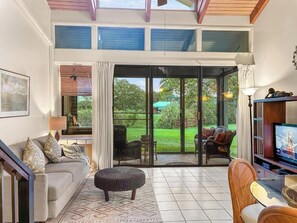 A spacious living room with a sofa, ottoman, and television. - 1 FREE NIGHT! Please Inquire. 2B/2B+Loft. Fully AC (Kahuku)